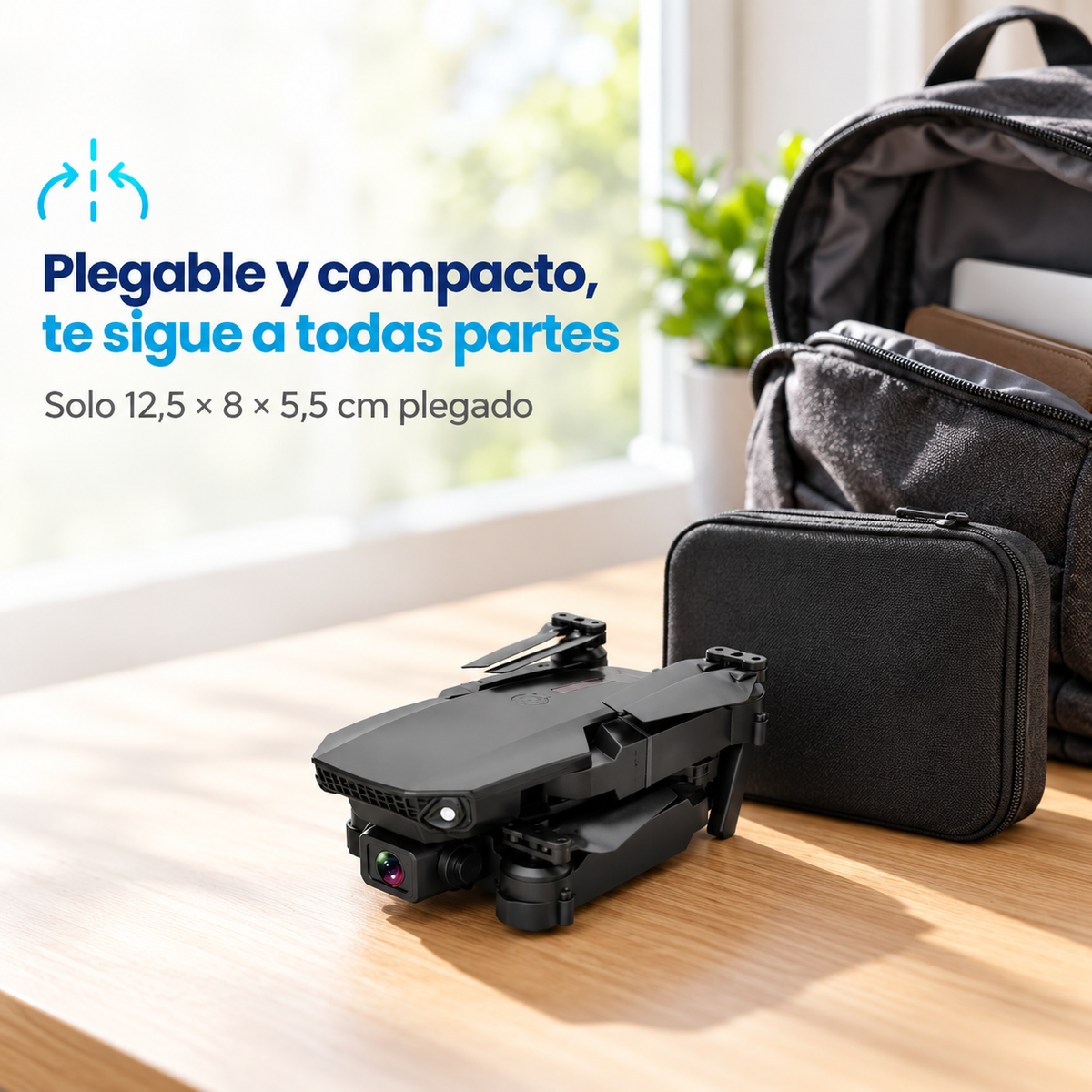 Dron plegable negro junto a su estuche y una mochila abierta sobre una mesa de madera
